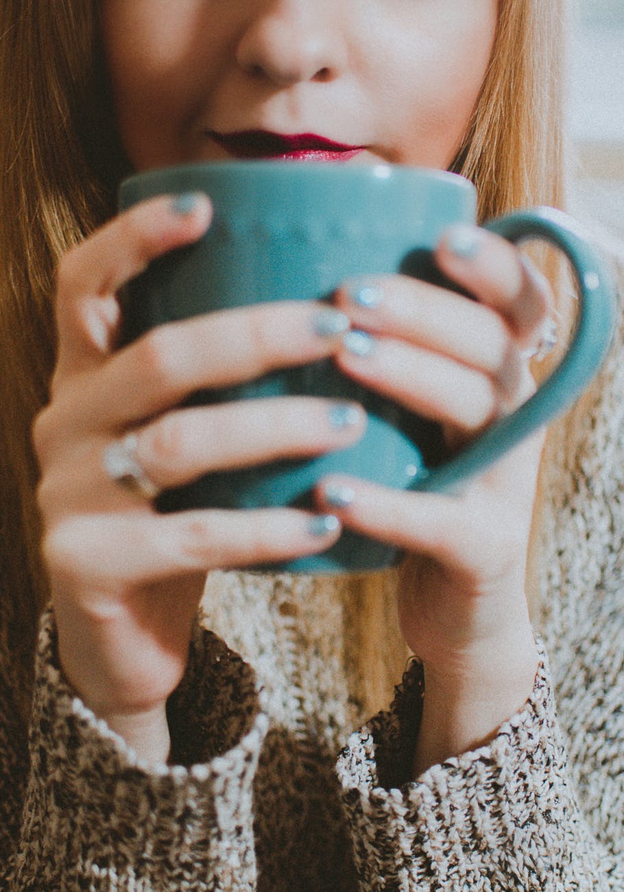 woman holding blue ceramic mug